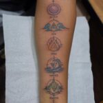 A vertical forearm tattoo displaying five elemental symbols labeled Spirit, Air, Fire, Water, and Earth.