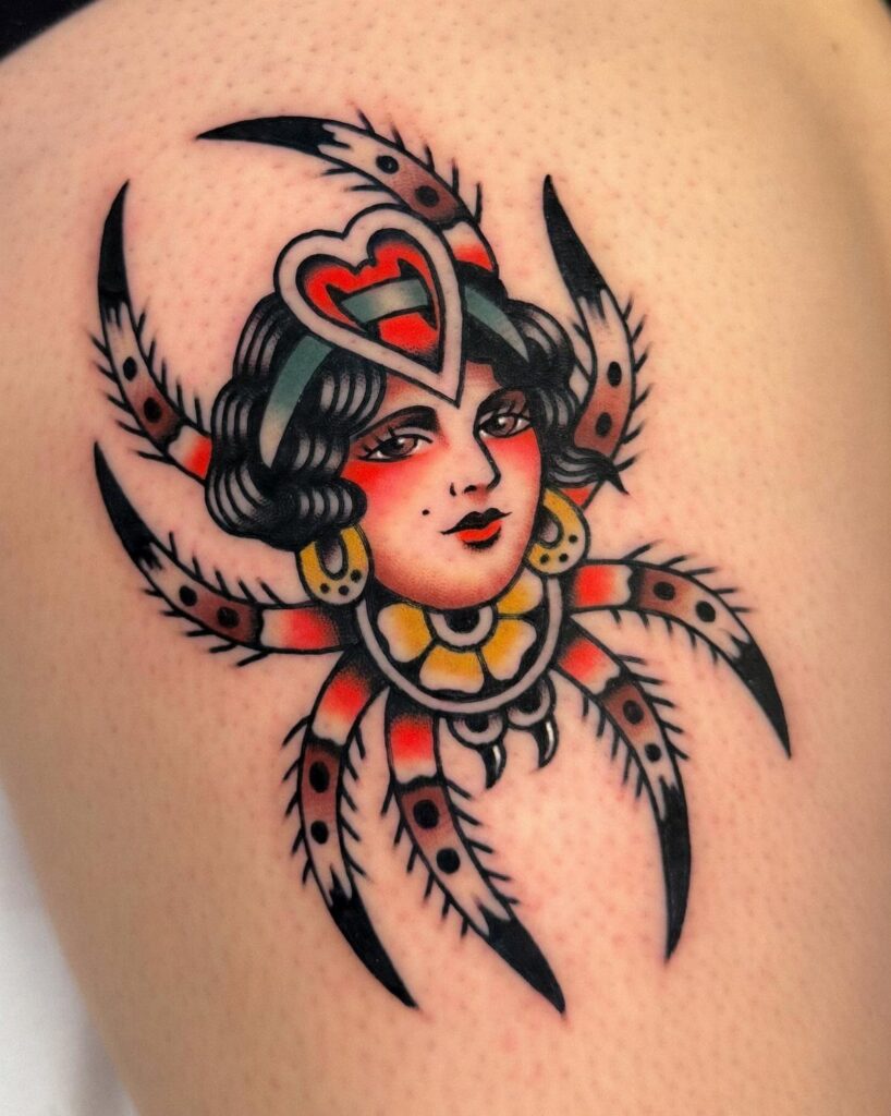 A traditional style tattoo of a woman's face integrated into a colorful spider design on skin.